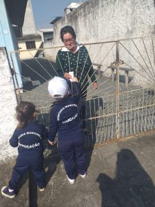 Entrega de panfleto para moradores que assistiram a caminhada dos alunos da CMEI Professora Lenita de Souza Gaya.