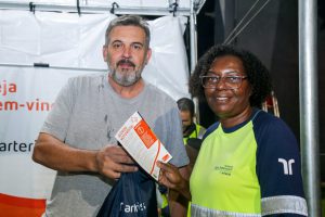 Entrega de brinde com kit lanche e panfleto com orientações.