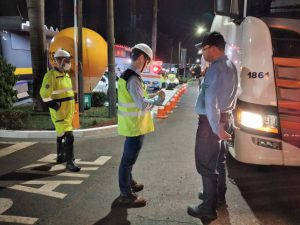 Ação educativa para caminhoneiros - troca de lâmpadas, exame básico com equipe do resgate, orientações sobre trânsito seguro com equipe da concessionária