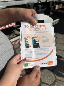 Motorista orientado e recebendo panfleto Arteris